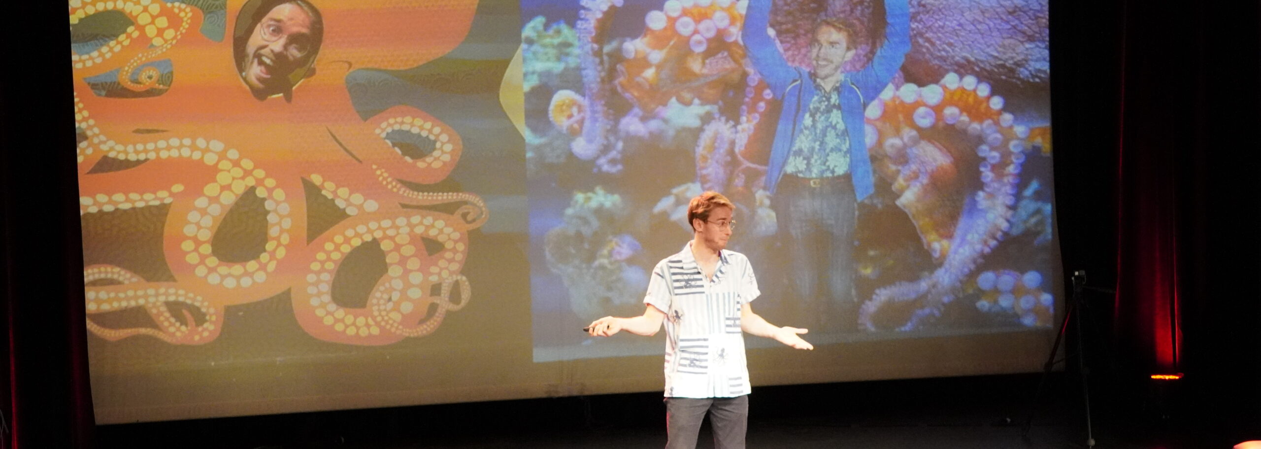 Michael Morari on stage at Science Slam Basel with octopus pictures on the screen